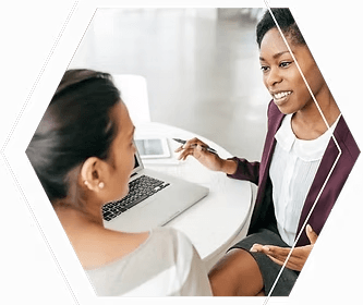 Two women discussing laptop screen consultation